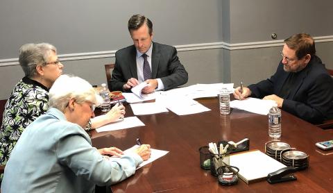 Carole Shinnick, SSND; Christine Beckett, SCN; and John Pavlik, OFM Cap with the lawyer signing paperwork for the sale of the office building